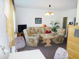 ein Wohnzimmer mit einem Sofa, einem Tisch und Stühlen in der Unterkunft Holiday Home Zerna by Interhome in Bad Muskau