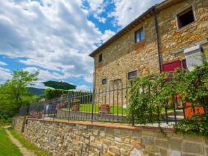 a brick building with a fence and an umbrella at Holiday Home Locazione Turistica Selvapiana by Interhome in Greve in Chianti