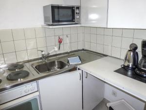 eine kleine Küche mit einer Spüle und einer Mikrowelle in der Unterkunft Apartment Castagnola - Utoring-31 by Interhome in Lugano