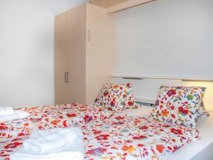 Habitación pequeña con cama con sábanas florales. en Apartment Castagnola - Utoring-31 by Interhome, en Lugano