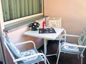 a small table with two chairs and a bottle and flowers on it at Apartment Castagnola - Utoring-31 by Interhome in Lugano