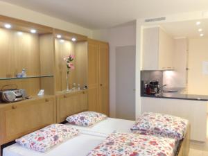 ルガノにあるApartment Castagnola - Utoring-8 by Interhomeのベッド2台とキッチンが備わる小さな客室です。
