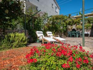 eine Gruppe von Stühlen und Blumen in einem Garten in der Unterkunft Apartment Jasna-5 by Interhome in Pinezici