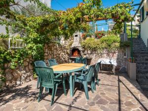 eine Terrasse mit einem Tisch, Stühlen und einem Kamin in der Unterkunft Apartment Jasna-5 by Interhome in Pinezici