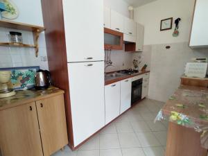 kuchnia z białymi szafkami i białą lodówką w obiekcie Apartment Parco Musadino by Interhome w mieście Porto Valtravaglia