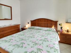sypialnia z łóżkiem z narzutą w kwiaty w obiekcie Apartment Parco Musadino by Interhome w mieście Porto Valtravaglia +15 zdjęć