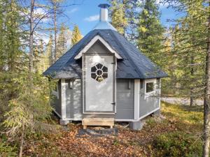 ein kleines Haus mit einem blauen Dach im Wald in der Unterkunft Holiday Home Varilan lomamajat nr1 by Interhome in Ruka