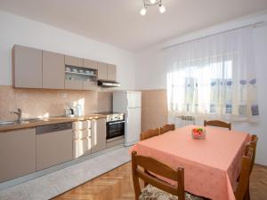 une cuisine avec une table recouverte d'une nappe rose dans l'établissement Apartment Šime by Interhome, à Brodarica