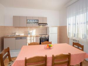 - une cuisine avec une table et un bol de fruits dans l'établissement Apartment Šime by Interhome, à Brodarica