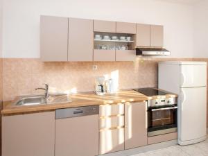 een keuken met witte kasten en een witte koelkast bij Apartment Šime by Interhome in Brodarica