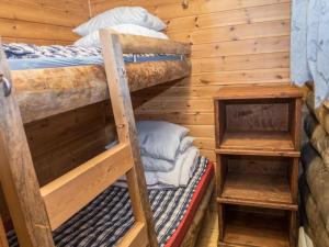 two bunk beds in a room with wooden walls at Holiday Home Saukkokumpu 3 by Interhome in Ruka