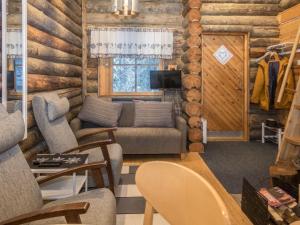 a living room with a couch and chairs in a log cabin at Holiday Home Saukkokumpu 3 by Interhome in Ruka