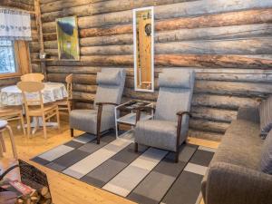 a room with chairs and a table in a log cabin at Holiday Home Saukkokumpu 3 by Interhome in Ruka