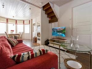 een woonkamer met een rode bank en een glazen tafel bij Holiday Home Vuosselinhovi a by Interhome in Ruka