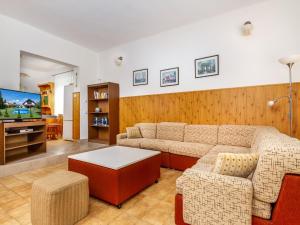 a living room with a couch and a tv at Holiday Home Grand Jardin by Interhome in Balatonkeresztúr