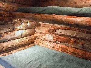 a log wall with a bed in a room at Holiday Home Seitsemän savua 6 by Interhome in Ruka