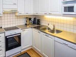 a kitchen with white cabinets and a sink at Holiday Home Karhunvartijan tupa a6 by Interhome in Ruka