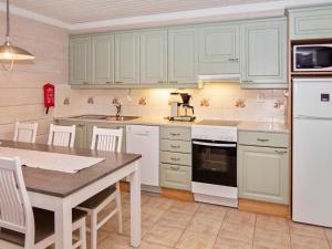 a kitchen with white appliances and a table with chairs at Holiday Home Jäkälärinne 2b - 24 by Interhome in Ruka