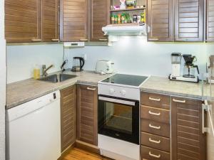 eine Küche mit Spüle und Herd oberen Backofen in der Unterkunft Holiday Home Purnukylä 6 by Interhome in Ruka + 14 Fotos