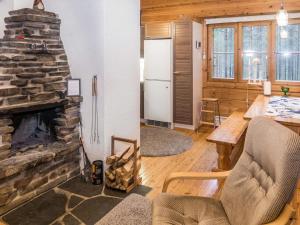 ein Wohnzimmer mit einem Steinkamin und einem Tisch in der Unterkunft Holiday Home Purnukylä 6 by Interhome in Ruka