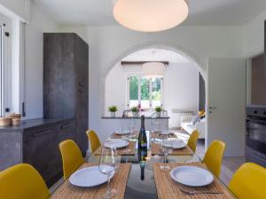 un comedor con una mesa con copas de vino y sillas amarillas en Holiday Home Villa Zaferina - CCO113 by Interhome, en Carriola 31 fotos más