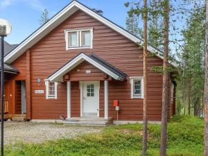 a red house with a white door at Holiday Home Kiela 2 by Interhome in Levi