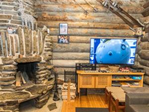 a living room with a fireplace in a log cabin at Holiday Home Lapinkoto by Interhome in Ruka