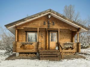 a log cabin with a porch in the snow at Holiday Home Pikkupöllö in Kaaresuvanto