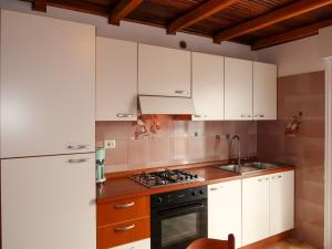 a kitchen with white cabinets and a stove top oven at Apartment Brida by Interhome in Caldonazzo