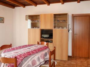 カルドナッツォにあるApartment Brida by Interhomeのベッドルーム1室(ベッド1台付)、木製キャビネットが備わります。