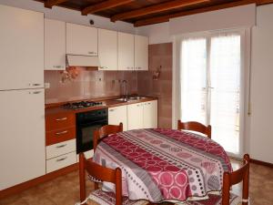 a kitchen with a table and a kitchen with white cabinets at Apartment Brida by Interhome in Caldonazzo