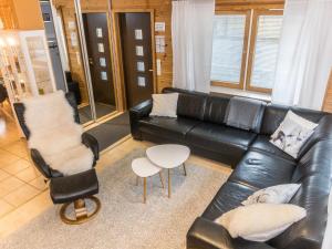 レヴィにあるHoliday Home Luxporo by Interhomeのリビングルーム(黒い革張りのソファ、椅子2脚付)