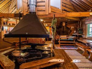 ein großer Raum mit Kamin in einer Blockhütte in der Unterkunft Holiday Home Kuusenkatve by Interhome in Ruokonen