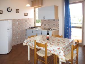 - une cuisine avec une table et une bouteille de vin dans l'établissement Apartment Riviera 5 by Interhome, à Marina di Cecina 23 autres photos