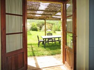 eine offene Tür zu einer Terrasse mit einem Picknicktisch in der Unterkunft Holiday Home Ginestra by Interhome in Canneto