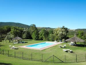 ein Pool auf einem Feld mit Sonnenschirmen in der Unterkunft Holiday Home Ginestra by Interhome in Canneto