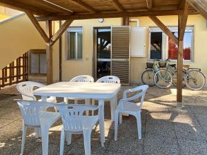 Apartment Riviera 1 by Interhome في مارينا دي سيسينا: طاولة بيضاء وكراسي على الفناء