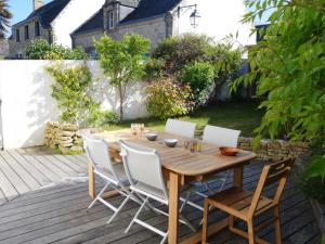 a wooden table and chairs on a patio at Holiday Home la Voile by Interhome in La Trinité-sur-Mer