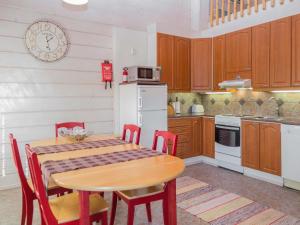 cocina con mesa, sillas y nevera blanca en Holiday Home Mulligan by Interhome en Tahkovuori
