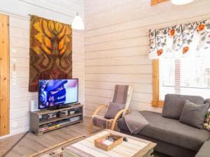 sala de estar con sofá y TV en Holiday Home Mulligan by Interhome en Tahkovuori