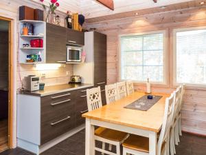 uma cozinha com uma mesa de madeira e cadeiras em Holiday Home Alppituulahdus 10a by Interhome em Valkeinen