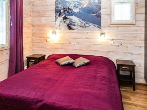 a bedroom with a purple bed with two pillows on it at Holiday Home Alppituulahdus 10a by Interhome in Valkeinen