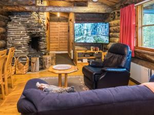 una baita di tronchi con soggiorno e camino in pietra di Holiday Home Lapinkulta by Interhome a Ruka