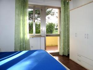 une chambre avec un lit bleu et une fenêtre dans l'établissement Apartment Riviera 6 by Interhome, à Marina di Cecina 23 autres photos