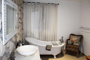 a bathroom with a bath tub and a sink at Kleinzee Oceanfront Guesthouse in Gansbaai +93 photos