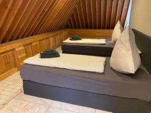 two beds are sitting in a room with wood at Villa Arche 1 in Neuenkirchen-Vörden