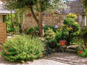 a garden with flowers and a stone wall at Holiday Home Manoir des Halles by Interhome in Plouescat