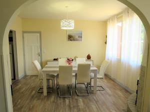 a dining room with a white table and chairs at Holiday Home Les Hirondelles - ADS185 by Interhome in Andernos-les-Bains