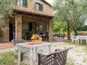 Corchiano的住宿－Holiday Home Casale Ai Noccioli - LVC165 by Interhome，房子前面的一张桌子和椅子