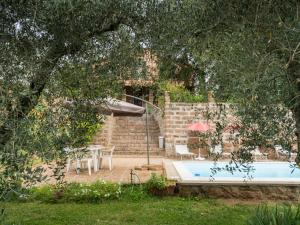 Corchiano的住宿－Holiday Home Casale Ai Noccioli - LVC165 by Interhome，一个带桌子和遮阳伞的游泳池